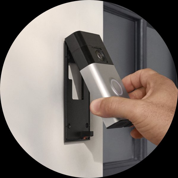 Una mano fija el Timbre con cámara inalámbrico Ring a un soporte instalado al lado de una puerta principal.