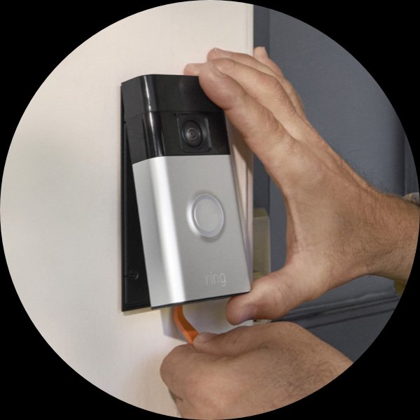 Un par de manos usan una herramienta para retirar el Timbre con cámara inalámbrico Ring de un soporte de pared.