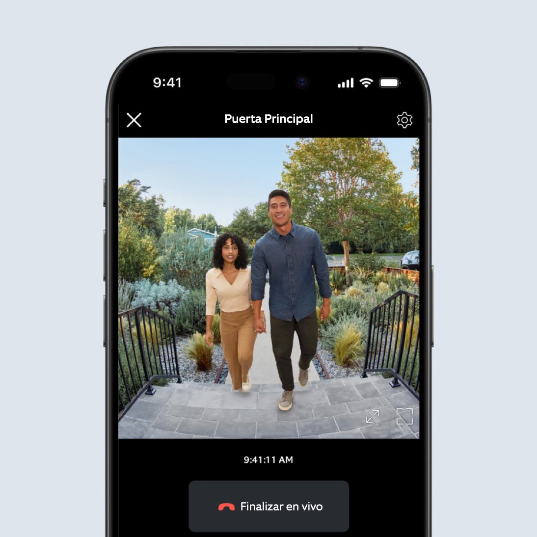La pantalla de un teléfono muestra un video en la app de Ring de un hombre y una mujer que caminan hacia una escalera cerca de la cámara.